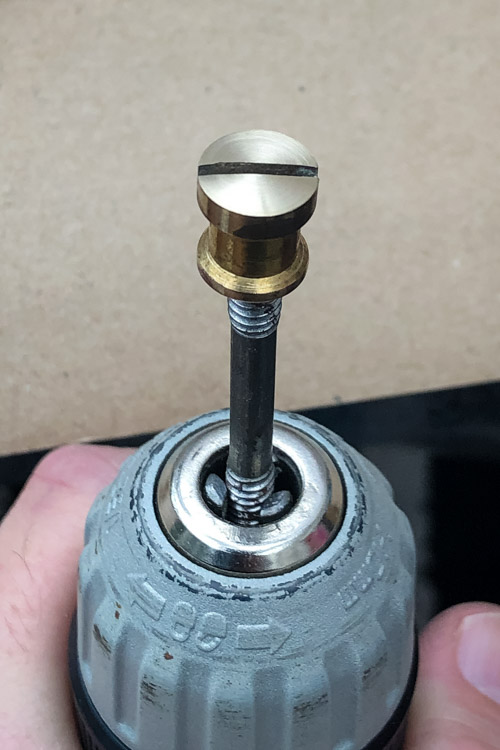 Brass nut mounted in a drill for polishing